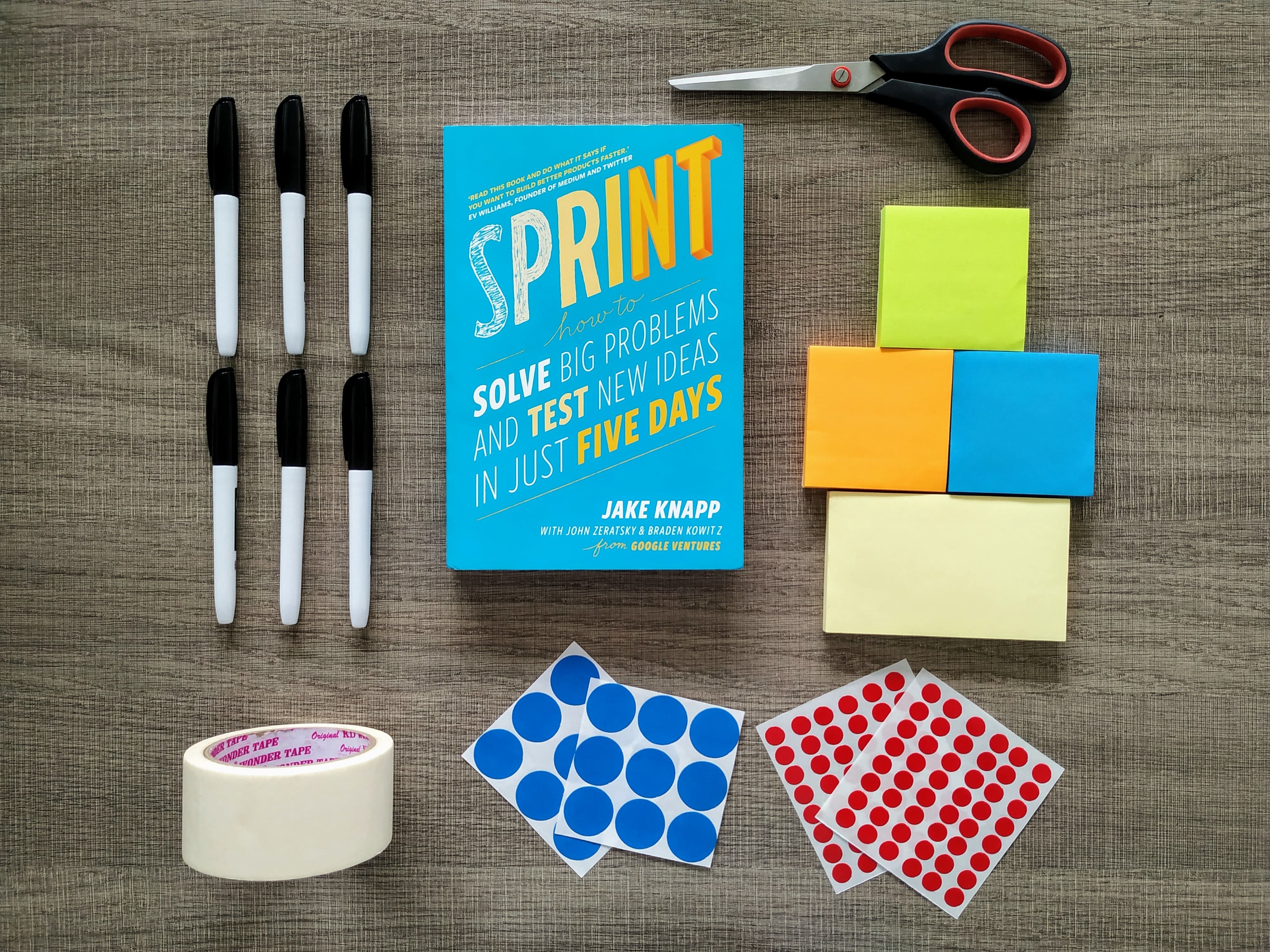 Design sprint materials; sharpies, post-its, voting stickers, scissor, Sprint Book