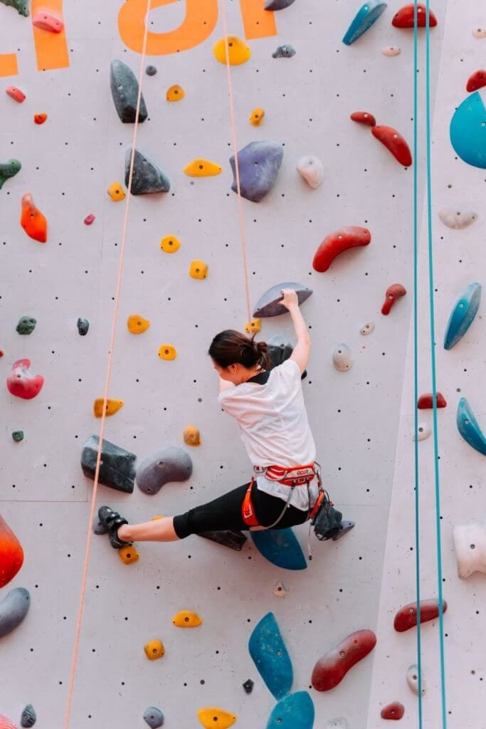 Une femme grimpant sur un mur d'escalade